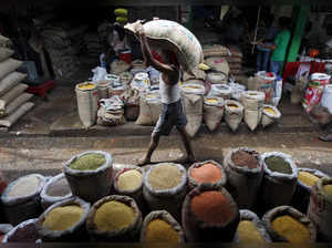A labourer carries a sack filled with pulses at a wholesale pulses market in Kolkata