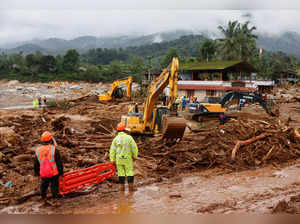 Rescuers hold a stretcher as the search for survivors continues after several landslides hit the hills in Wayanad district, in Kerala