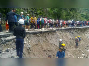 Rudraprayag: Devotees walk on the side of a washed-away road during Kedarnath Ya...