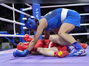 China's Li Qian, left, and India's Lovlina Borgohain fall to the mat in their wo...