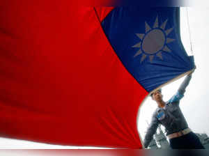 FILE PHOTO: A sailor holds a Taiwan flag on the Navy's 124th fleet Lafayette frigate during a model units tour in Kaohsiung