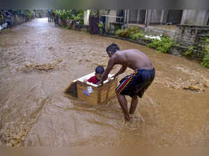 Guwahati: Children play on a flooded street after monsoon rainfall, in Guwahati....