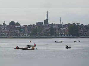 Srinagar: Men row boats amid rains, in Srinagar