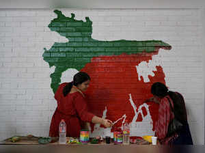 Students paint Bangladesh map on a wall alongside a road in Dhaka