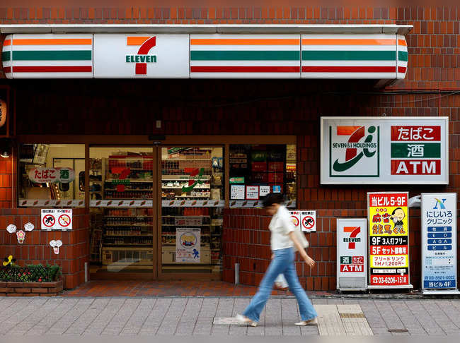 A pedestrian walks past Japan's Seven & I’s 7-Eleven convenience store in Tokyo