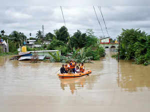 Rescuers from Tripura Disaster Management Authority evacuate flood-affected people to a safer place, on the outskirts of Agartala