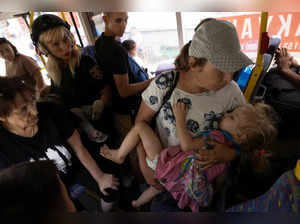 Local residents enter an evacuation bus as they flee Russian troop advances in Pokrovsk