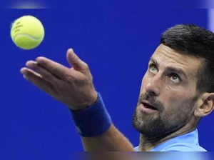 Novak Djokovic, of Serbia, serves to Alexei Popyrin, of Australia, during a thir...