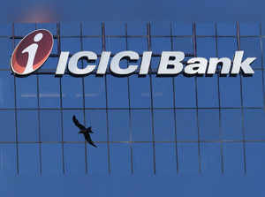 A bird flies past the facade of the ICICI bank head office in Mumbai