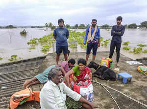 Vijayawada: People wait on the roof of a house for evacuation from a flood-affec...