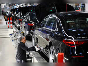 A worker attaches a part to a Mercedes-Maybach car on a production line of "Factory 56" in Sindelfingen