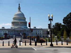 A man passes by the U.S. Capitol on his scooter in Washington