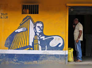 FILE PHOTO: A dealer selling Ambuja cement speaks on his phone at his shop in Ahmedabad