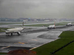 Mumbai: Planes sit on the wet tarmac at the airport, in Mumbai. Many flights wer...