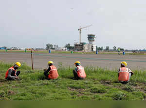 Labourers work at the site of the ongoing construction of Noida International Airport (NIA) during a media visit to the project site at Noida