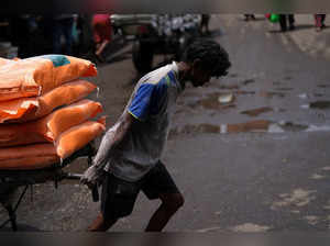 A labourer pulls a handcart loaded with flour bags in a market area in Colombo