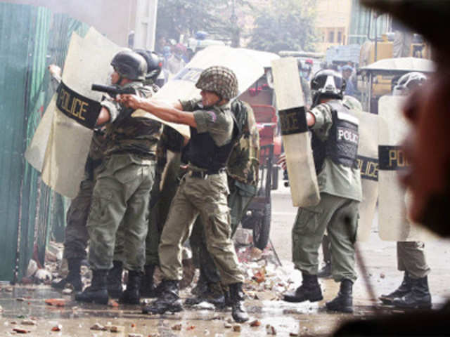 Riot police officer fires tear gas during clashes in Phnom Penh
