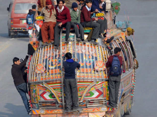 Pakistanis travel on a overloaded public transport