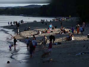 People rest on the beach on the coast of Gdansk Bay, part of the Baltic Sea, during a summer holiday season in the touristic city of Gdynia