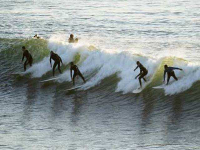 Surfers drop in on the same wave off the coast of Encinitas