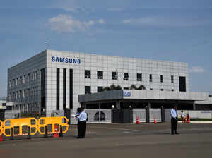 FILE PHOTO: Security guards stand outside a Samsung facility during a strike by the factory workers demanding higher wages in Sriperumbudur