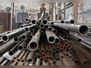 A worker stacks steel pipes in the western Indian city of Ahmedabad