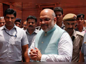 India's Home Minister Amit Shah greets the media upon his arrival at the home ministry in New Delhi