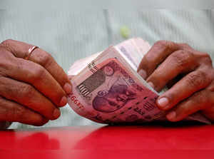 FILE PHOTO: A man counts Indian currency notes inside a shop in Mumbai