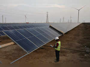 A technician checks the movement of an Automated cleaning brush installed over solar panels in Khavda Renewable Energy Park of Adani Green Energy Ltd (AGEL), in Khavda