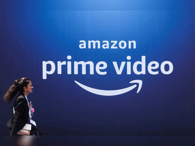 FILE PHOTO: A woman walks past a hoarding of Amazon Prime Video during an event in Mumbai