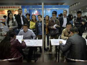 Job seekers speak to recruiters during their interviews at a job fair in Chongqing municipality