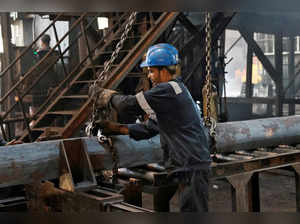 FILE PHOTO: An employee prepares to move a heavy bar of steel inside the ArcVac ForgeCast factory, in Hooghly district