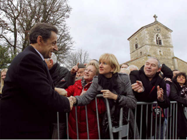Nicolas Sarkozy shakes hands with bystanders
