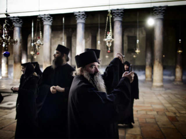 Christian Orthodox monks tour the Church of Nativity