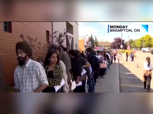 Thousands of Indian students stand outside a restaurant in Canada for jobs