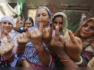 Jammu: West Pakistani Refugees (WPRs) show their inked fingers after casting the...