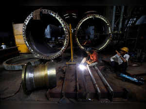 FILE PHOTO: A worker welds a cooling coil plate inside an industrial manufacturing unit on the outskirts of Ahmedabad