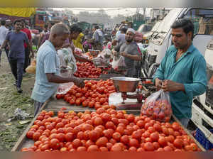 New Delhi: People purchase tomatoes at the Okhla vegetable market, in New Delhi....