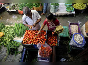 FILE PHOTO: FILE PHOTO: FILE PHOTO: Woman selects tomatoes from a vendor, at a wholesale market in Navi Mumbai