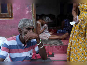 Upali Ranjith sits outside the house of his neighbor in Thotalanga, Colombo