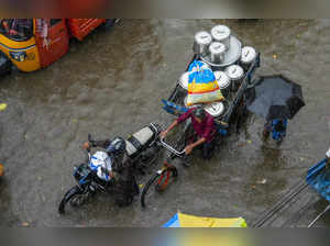 Chennai: People wade through a waterlogged road amid rains, in Chennai. (PTI Pho...