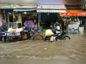 Chennai: People move through a waterlogged road amid rains, in Chennai. (PTI Pho...