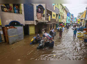 Chennai: People wade thrugh a heavily waterlogged road amid rains, in Chennai. (...