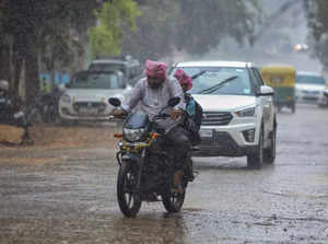 Bengaluru: People commute amid rains due to ‘Spawn’ cyclone, in Bengaluru, Karna...