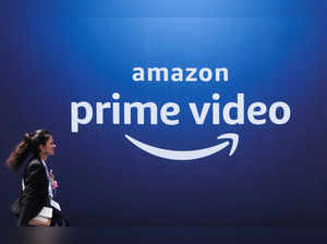 FILE PHOTO: A woman walks past a hoarding of Amazon Prime Video during an event in Mumbai