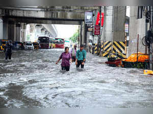 Chennai, Oct 15 (ANI): People wade through flooded street amid heavy rainfall, i...