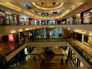 FILE PHOTO: Shoppers walk past stores at a mall in Mumbai