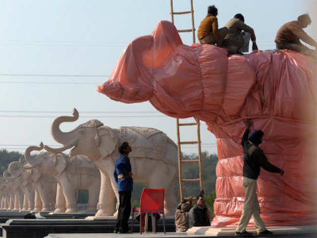 Workers wrap Elephant statues in Noida