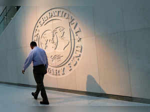 Man walks past the IMF logo at HQ in Washington