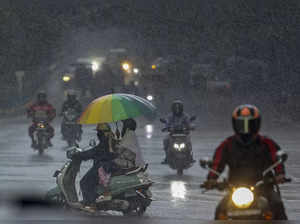 Bengaluru: Commuters move amid rainfall at Cubbon Road, in Bengaluru. (PTI Photo...